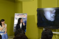 「呪い指輪の家」体験中の綾部を画面越しに見守る又吉（右）。