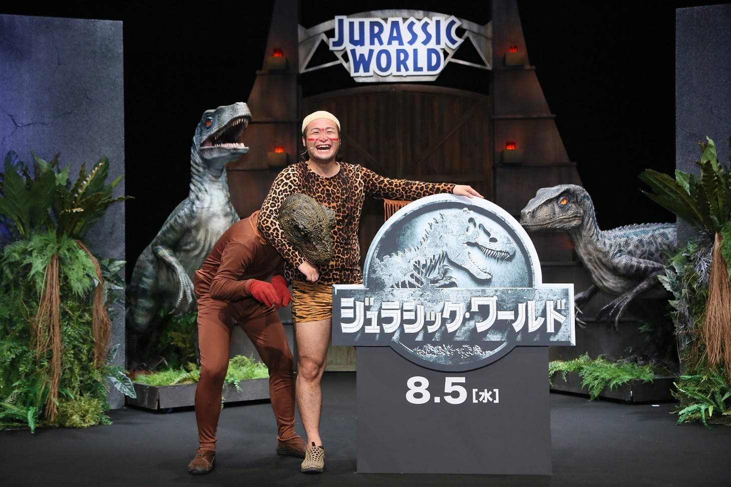 恐竜に扮した藤田に“ニーブラ”する石田（右）。
