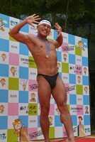 ボディビルのポージングを披露する春日。