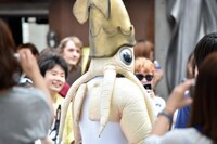街の人に囲まれるイカ大王。
