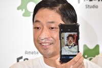 事故当時の写真を見せる団長安田。