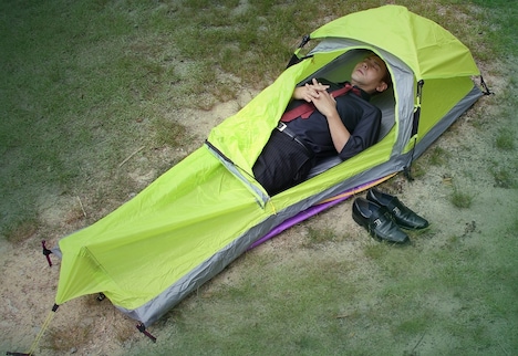 1人用テント「ワンタッチソロテント」に横たわるヒロシ。