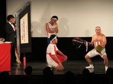 「池崎-1グランプリ2015」で優勝したサンシャイン池崎（中央奥）にトロフィーを渡すクールポコ。