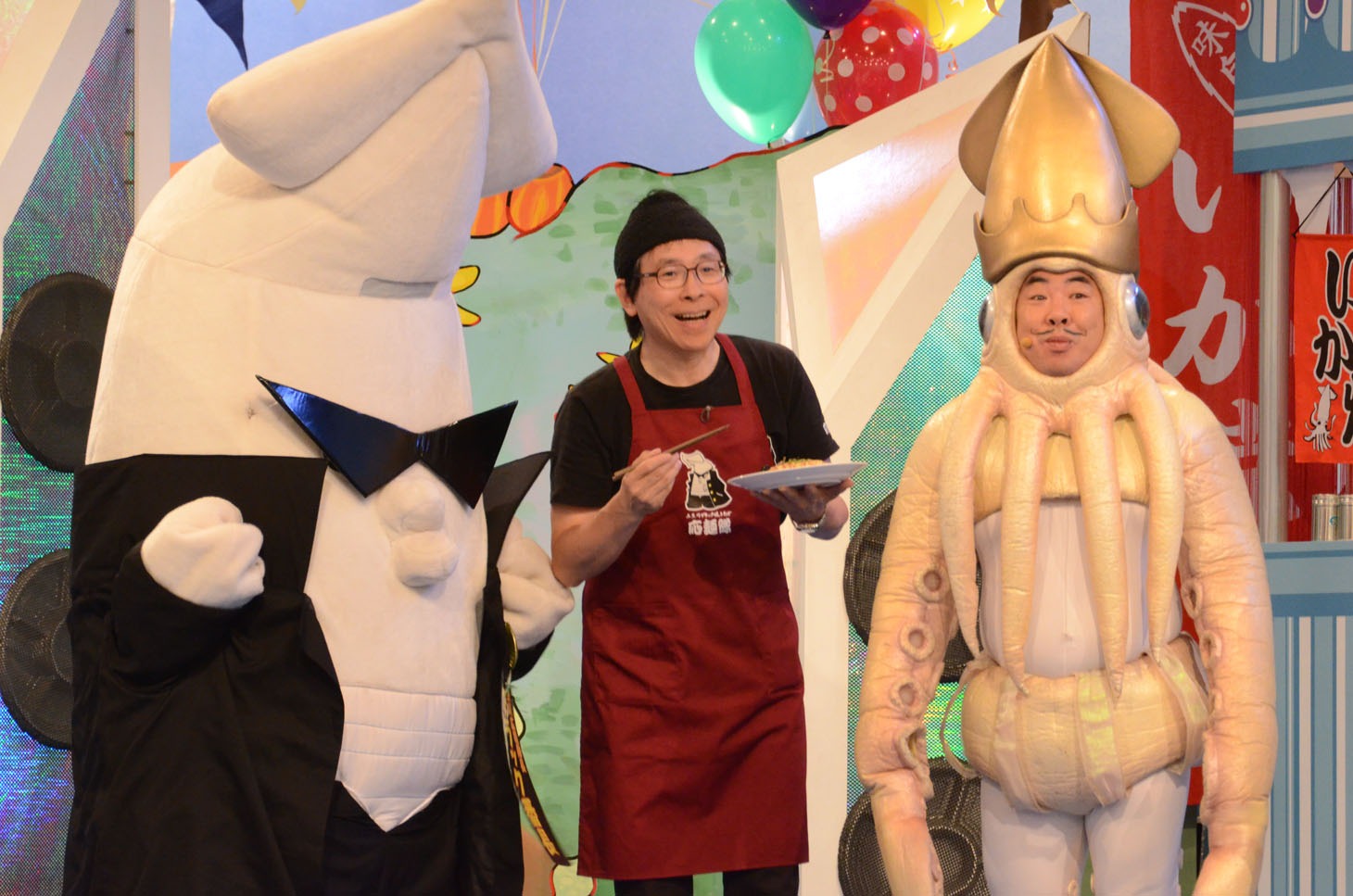 ブラック番長（左端）が持参した「糸魚川ブラック焼きそば」を試食するイカ大王（右端）。