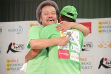 ゴールした間寛平を讃える西田敏行（左）。