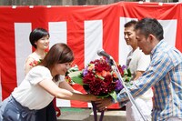 中京テレビの松岡陽子アナウンサーから花束を受け取る爆笑問題・太田（手前右）。(c)CTV