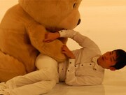 巨大な熊のぬいぐるみに襲われる石田。(c)ABC