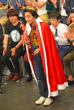 ジャングルポケットを代表し、トロフィー、王冠、ローブを受け取った斉藤。