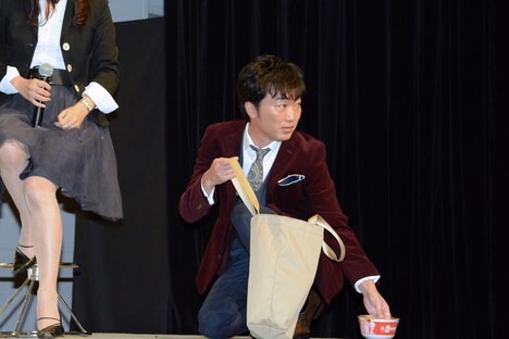 買い物袋から取り出した商品を地面に置くスピードワゴン小沢。