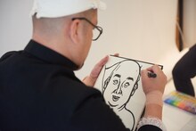 似顔絵を描く野性爆弾くっきー。