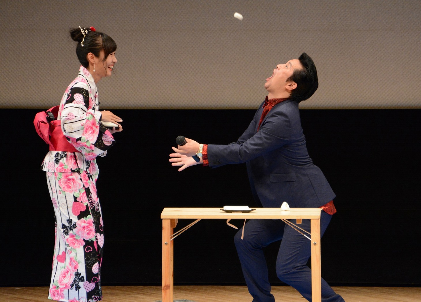 饅頭の口キャッチに挑戦する（左から）前田希美とアイパー滝沢。