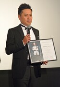 映画「007 スペクター」の公式認定アンバサダー任命状を受け取り、緊張気味の有田。