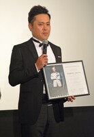 映画「007 スペクター」の公式認定アンバサダー任命状を受け取り、緊張気味の有田。