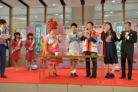 青森りんごを試食する登壇者たち。