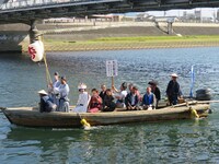 渡し舟に乗ってやって来る富士彦の妻。