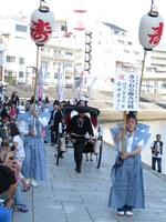 舟から降りて人力車で会場に向かう富士彦の妻。