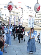 舟から降りて人力車で会場に向かう富士彦の妻。