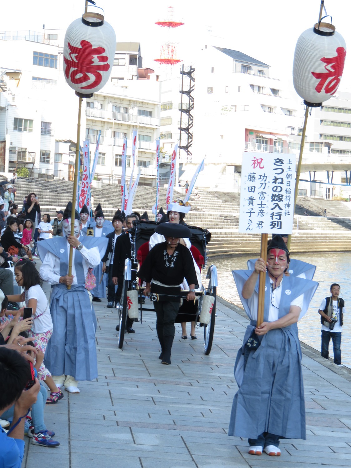 舟から降りて人力車で会場に向かう富士彦の妻。