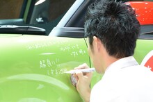 キャストのボディにメッセージを入れるしずる池田。