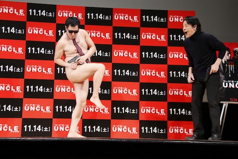 全裸に見えるポーズを披露するとにかく明るい安村(左)。