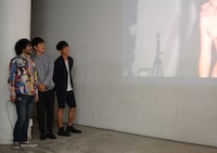 撮影のメイキング映像を鑑賞するジャルジャルと倉本美津留（右から）。