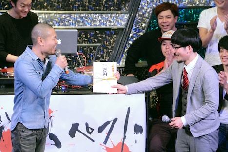 第1回「「ディスペクト ~芸人VSラッパー~」の様子。優勝賞金1万円を手にするDOTAMA(右)。