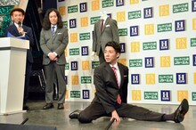 「ストレス対策スーツ」の動きやすさを実証するため、「綾部ポーズ」と題して開脚してみせるピース綾部。