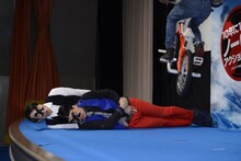 横たわるピスタチオ伊地知（手前）、なだぎ武（後方）の上をBMXプロライダーの池田貴広選手が飛び越える場面。