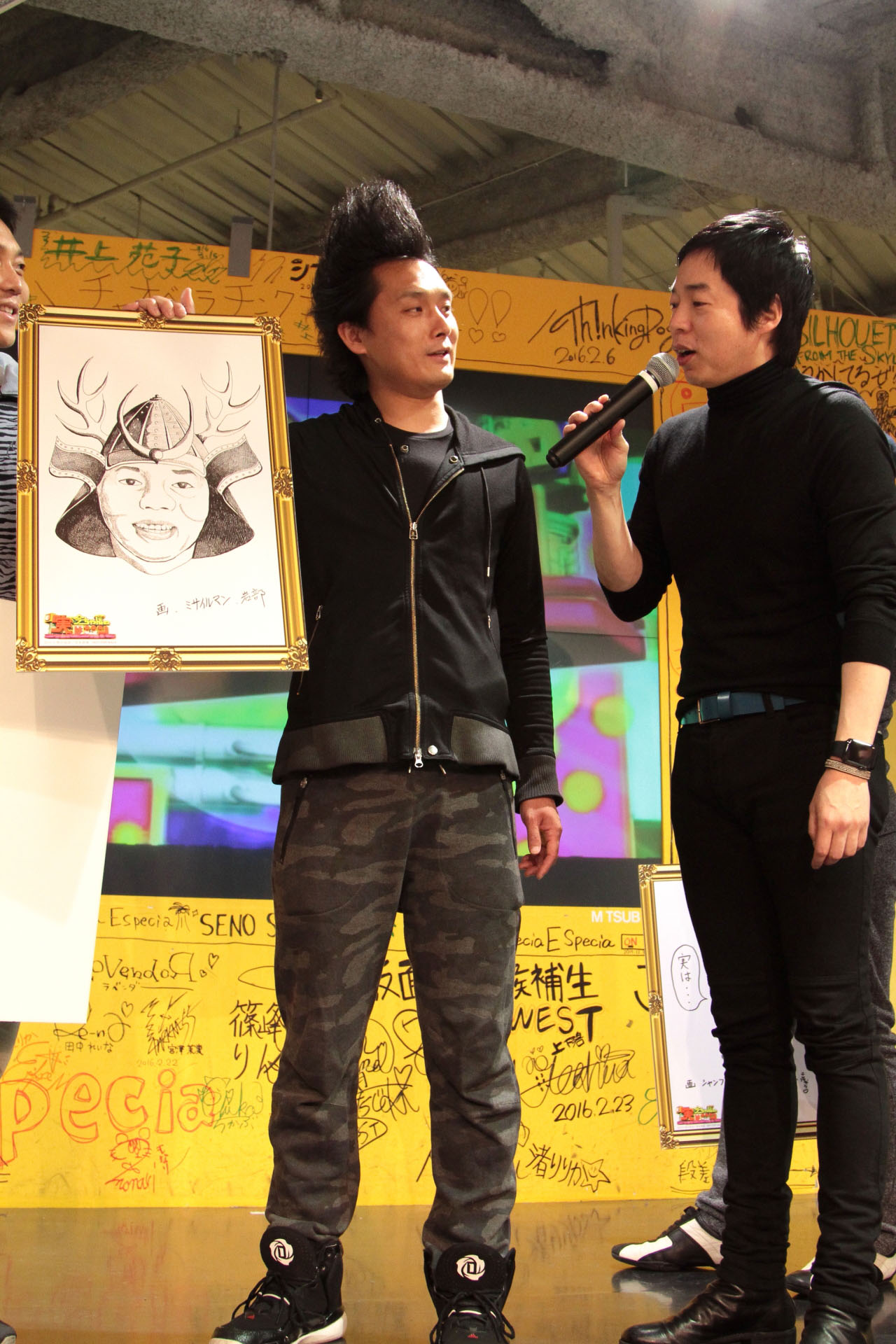 今田耕司の似顔絵を披露するミサイルマン岩部（左）。