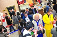 来場者に大入り袋を手渡す芸人たち。