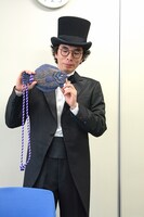 自身の作品「カレイPhone」を持った片桐仁。