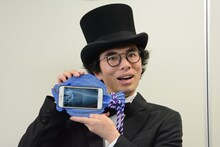 自身の作品「カレイPhone」を持った片桐仁。