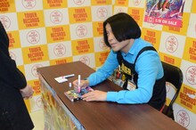 サインを入れつつファンの顔を見るのも忘れない永野。