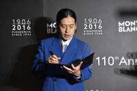 もらった万年筆でさっそくメッセージを書き入れるピース又吉。