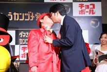 森永製菓の担当者とキスをするダチョウ倶楽部・上島（左）。