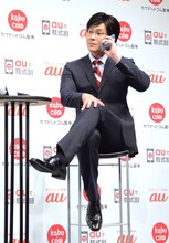 証券マンふうのポーズをとるメイプル超合金カズレーザー。