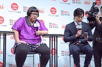 「kabu.com for au」を体験するメイプル超合金カズレーザー（右）。