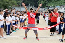 ゴールテープを切った間寛平。