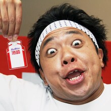 「サンシャイン池崎 コスチュームキーホルダー」を見せるサンシャイン池崎。