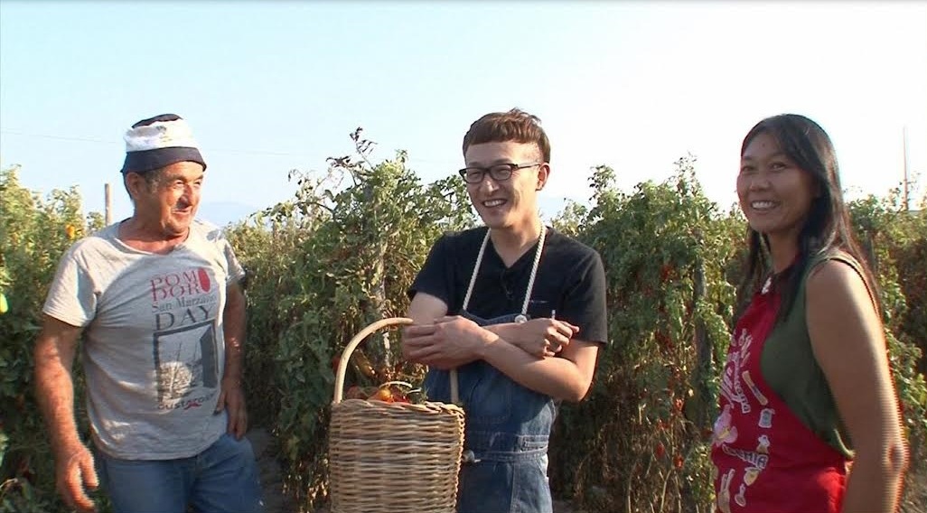 「世界の日本人妻は見た！SP」でイタリアのトマト生産農家を訪れるロバート馬場（中央）。(c)MBS
