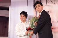 安倍晋三首相に扮して花束を渡すビスケッティ佐竹（右）。