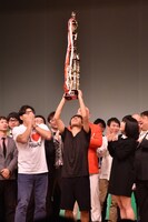 優勝トロフィーを高らかに掲げるアルコ＆ピース酒井（中央）。