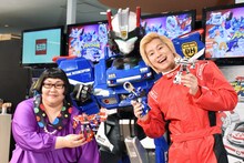 テレビアニメ新番組「トミカハイパーレスキュー ドライブヘッド 機動救急警察」の発表イベントに登場したメイプル超合金と、アニメキャラクターの「ドライブヘッド01 ソニックインターセプター」（中央）。