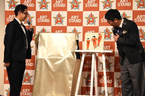 小木に贈りたいアート作品を紹介する矢作。セレクトの理由は「小木と言えばYMO」。