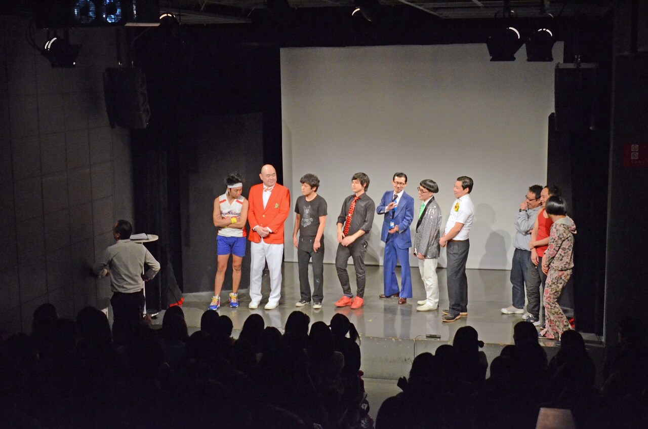 客席の壁に向かってPPAPを踊るみなみかわと、それを静かに見守る出場者たち。ノーセンス芸人はムチャぶりをしておいてリアクションはしないことが多い。