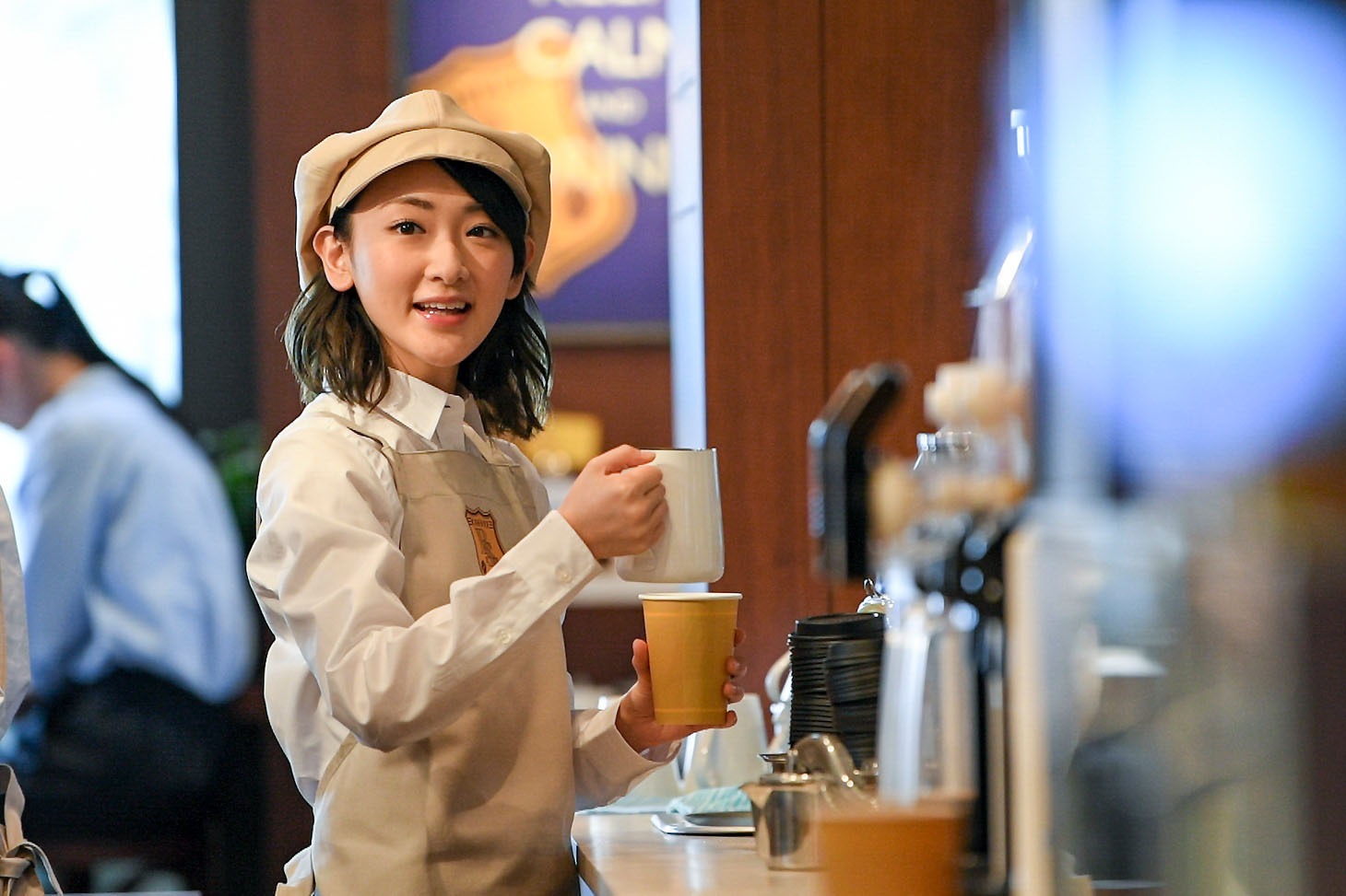 コーヒーショップ店員に扮する生駒里奈。