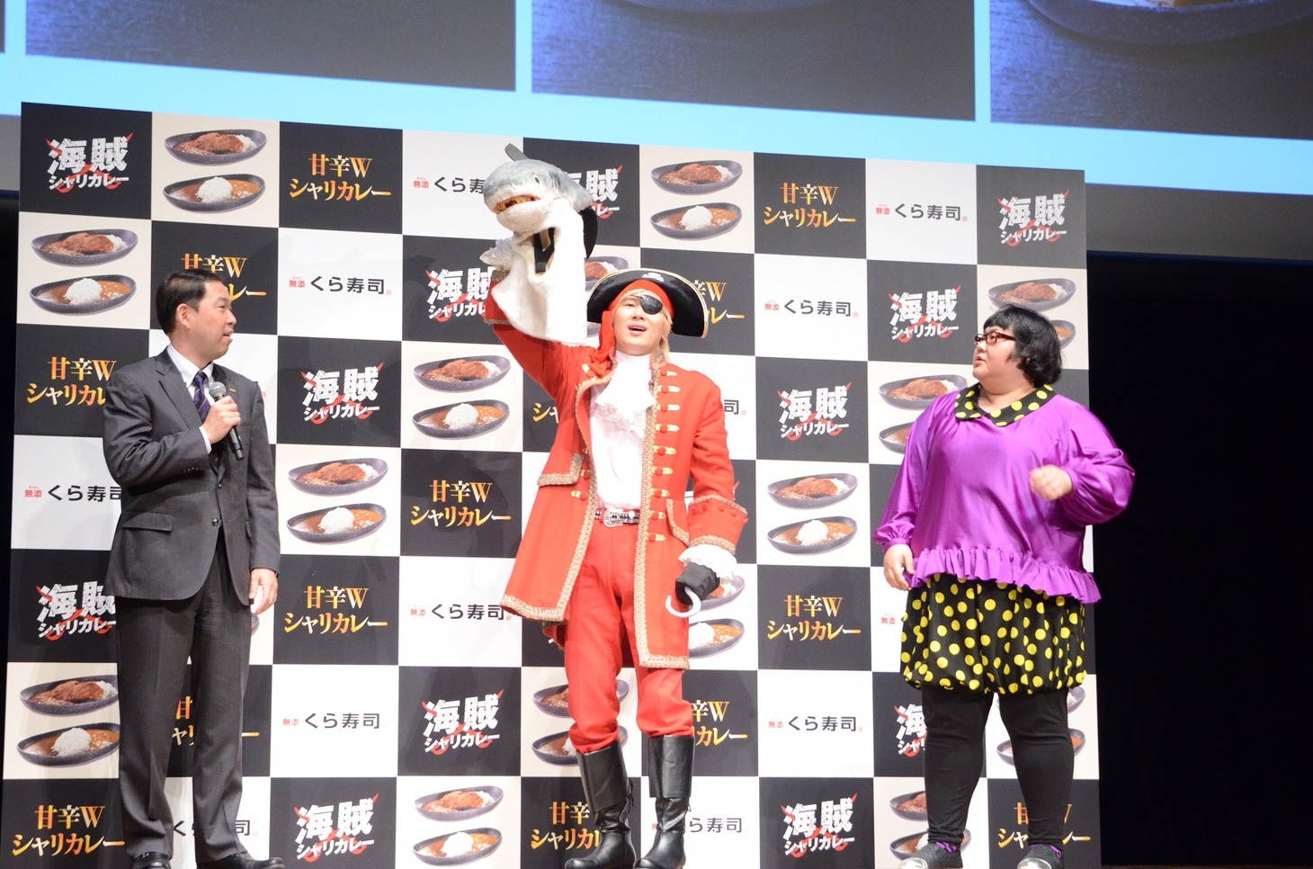 メイプル超合金・安藤（右）からサメの被り物を奪い取ったメイプル超合金・カズレーザー（中央）。