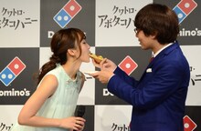 吉木りさ（左）にピザを食べさせてあげる三四郎・小宮（右）。