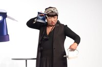 衣類スチーマーを持ってポーズを決めるYOKO FUCHIGAMI。