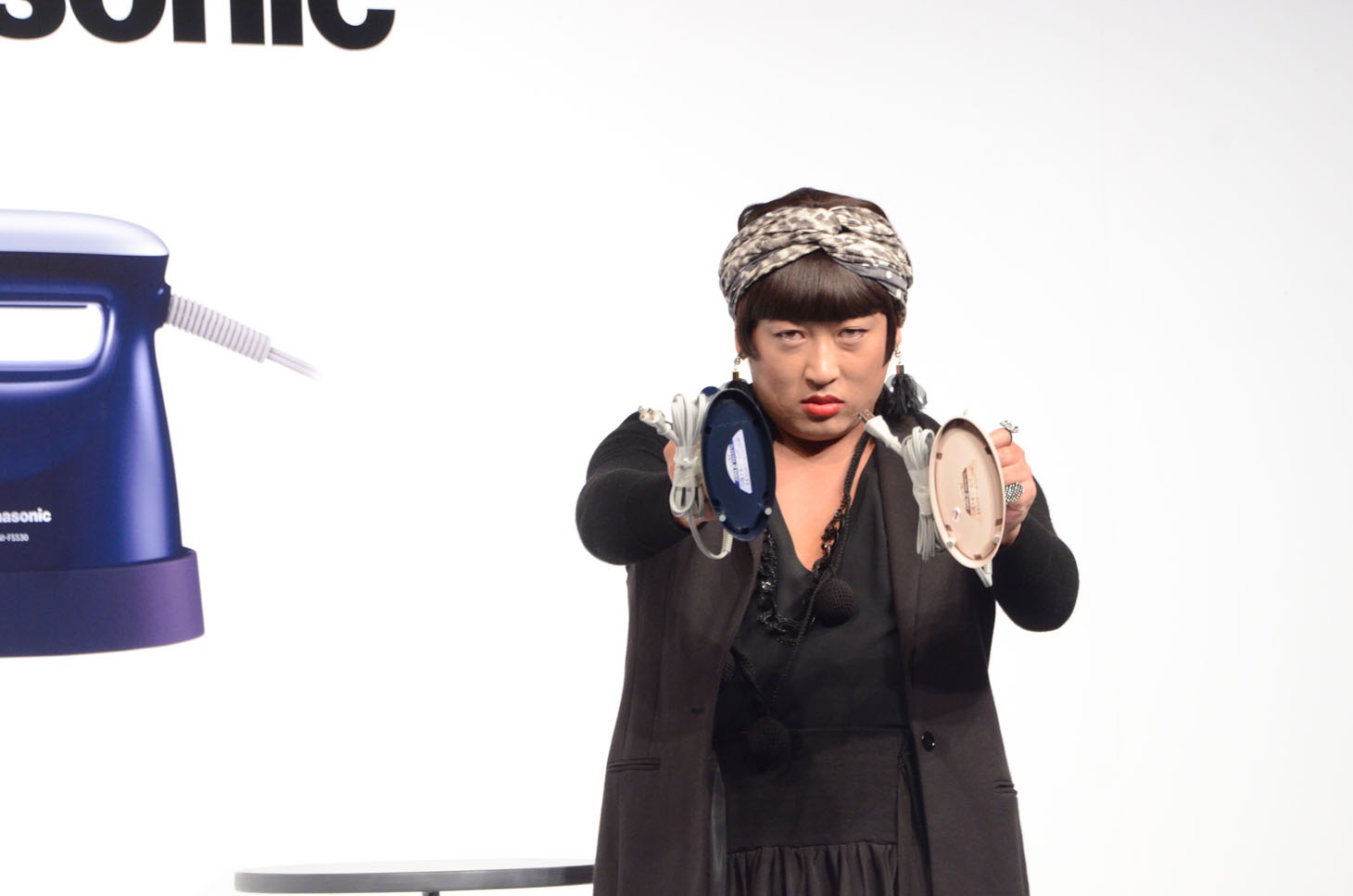 衣類スチーマーを持ってポーズを決めるYOKO FUCHIGAMI。